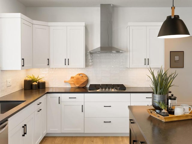 kitchen featuring light hardwood / wood-style floors, wall chimney exhaust hood, white cabinetry, and gas stovetop