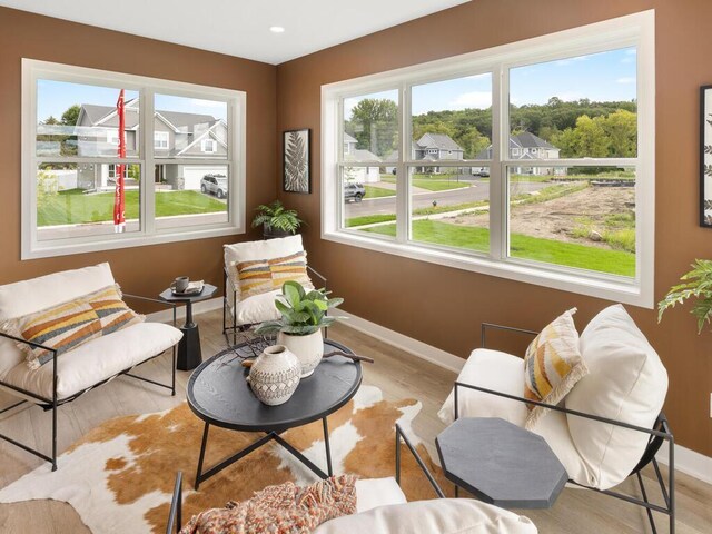 living area featuring baseboards, wood finished floors, and recessed lighting