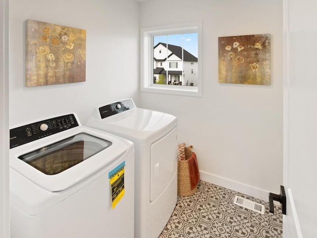 laundry area featuring washing machine and dryer and light tile patterned floors