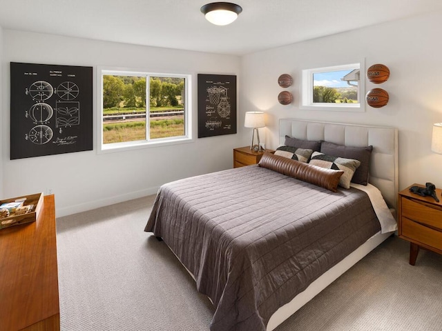 bedroom featuring carpet floors, multiple windows, and baseboards