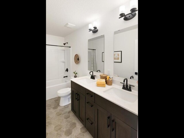 full bathroom with toilet, double vanity, and washtub / shower combination