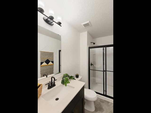 bathroom featuring a shower stall, toilet, a textured ceiling, and vanity