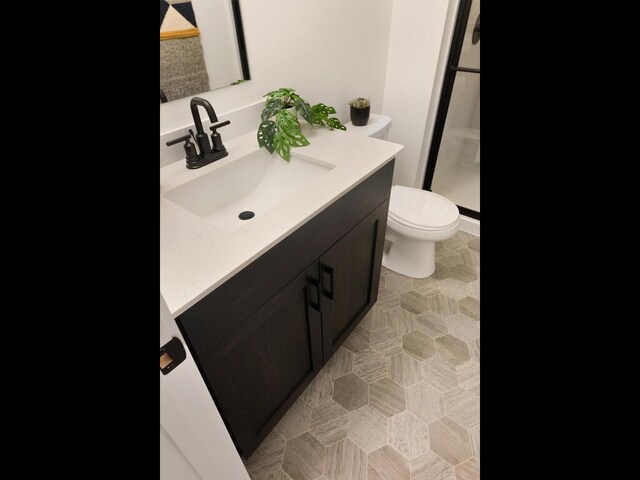 full bathroom with vanity, toilet, and a stall shower