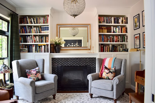 sitting room featuring a tile fireplace, built in shelves, and light hardwood / wood-style flooring