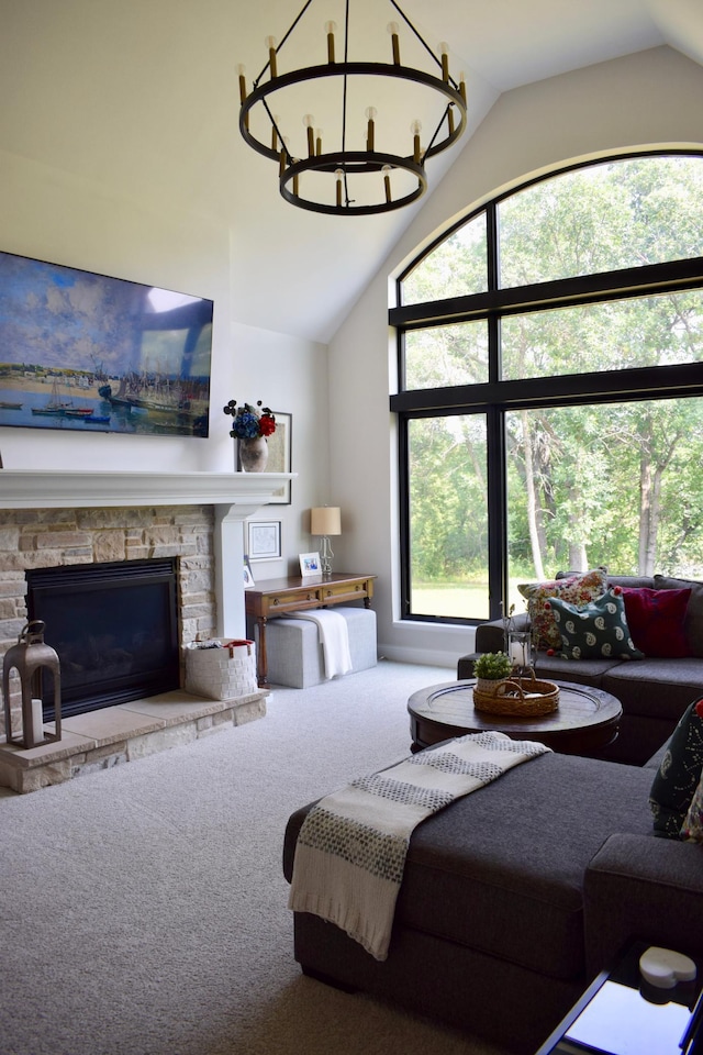 carpeted living room with a stone fireplace, lofted ceiling, and an inviting chandelier