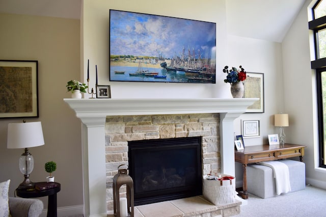 interior details with a stone fireplace and carpet floors