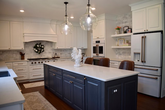 kitchen with white cabinets, custom exhaust hood, pendant lighting, and white appliances