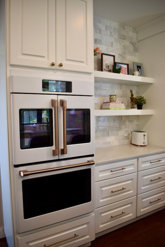 kitchen with dark hardwood / wood-style floors, white cabinetry, and double oven