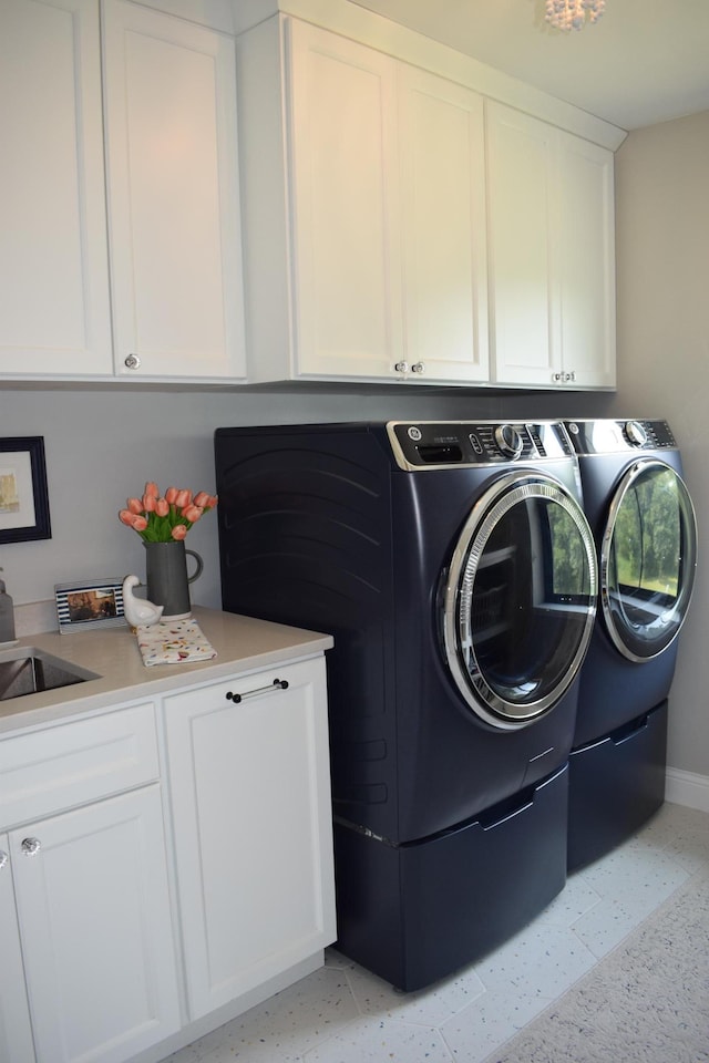 washroom featuring cabinets, independent washer and dryer, and sink