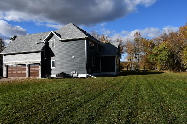 view of side of home with a lawn, a sunroom, and a garage