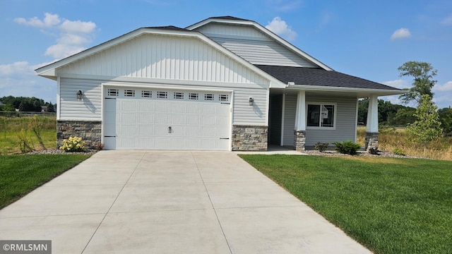 craftsman inspired home featuring a garage and a front lawn