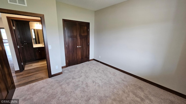 unfurnished bedroom featuring connected bathroom and carpet flooring