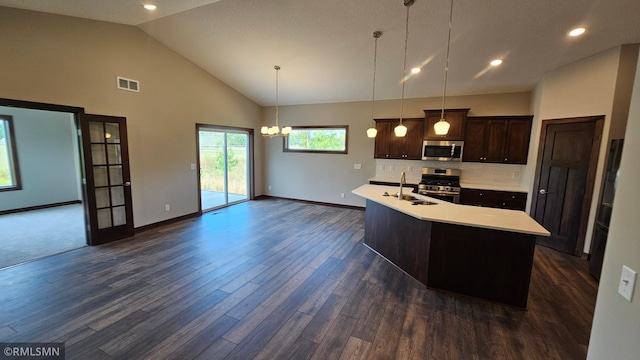 kitchen with appliances with stainless steel finishes, hanging light fixtures, decorative backsplash, dark hardwood / wood-style floors, and high vaulted ceiling