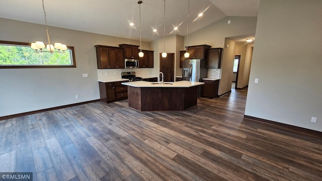 kitchen featuring dark wood-type flooring, tasteful backsplash, appliances with stainless steel finishes, and an island with sink