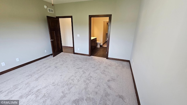 unfurnished bedroom with carpet floors and ensuite bath