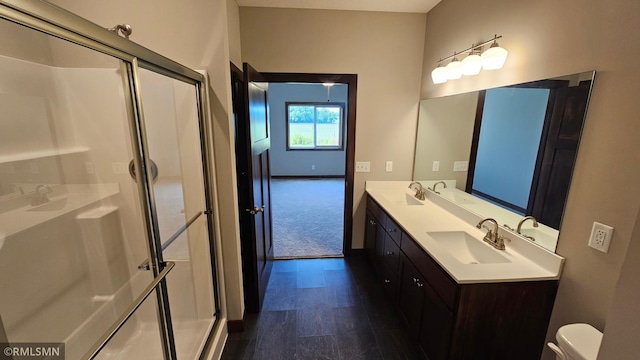 bathroom with double vanity, walk in shower, hardwood / wood-style floors, and toilet