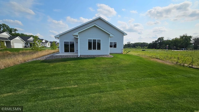 back of house featuring a garage and a lawn