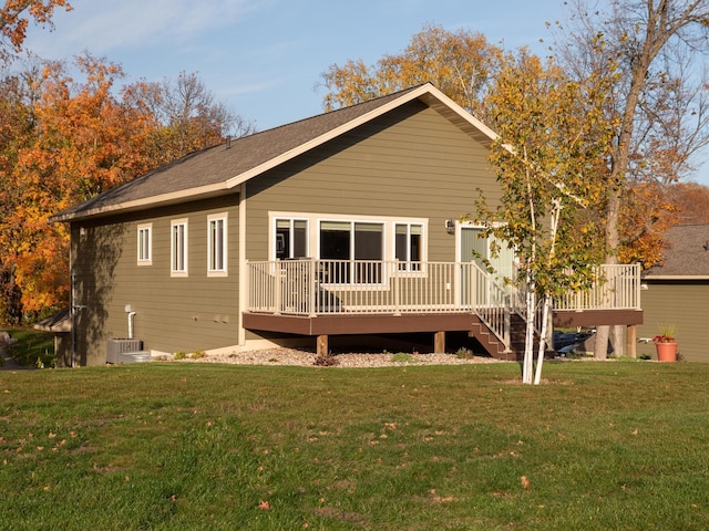 rear view of house with a deck, a lawn, and cooling unit