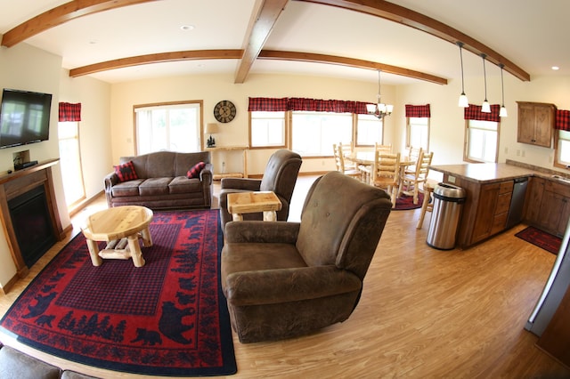 living room featuring beam ceiling, a chandelier, and light wood-type flooring