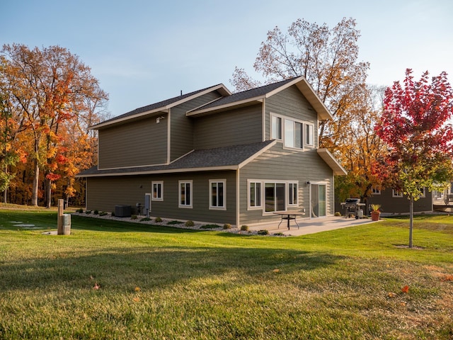 back of house featuring central AC unit, a patio, and a lawn