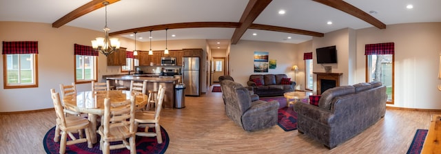 living room with sink, light wood-type flooring, a notable chandelier, and beam ceiling