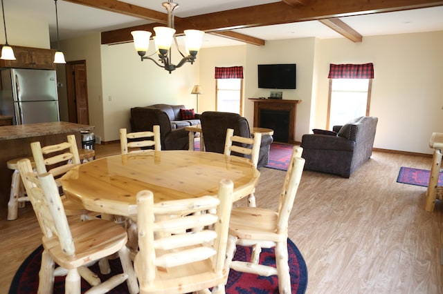 dining area with light hardwood / wood-style floors, beamed ceiling, and a wealth of natural light