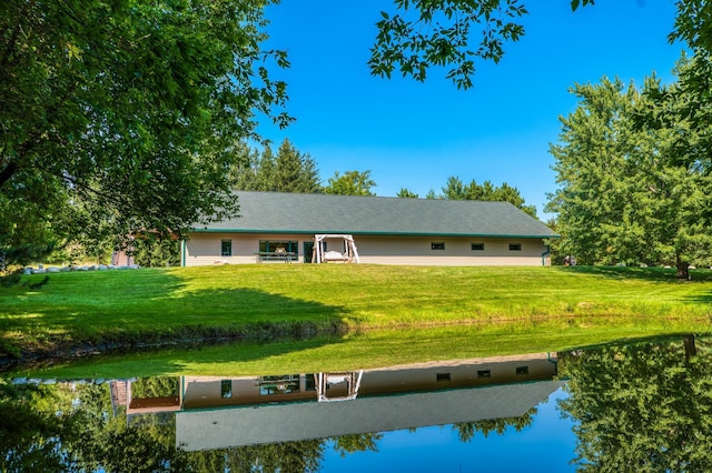 ranch-style home with a water view and a lawn