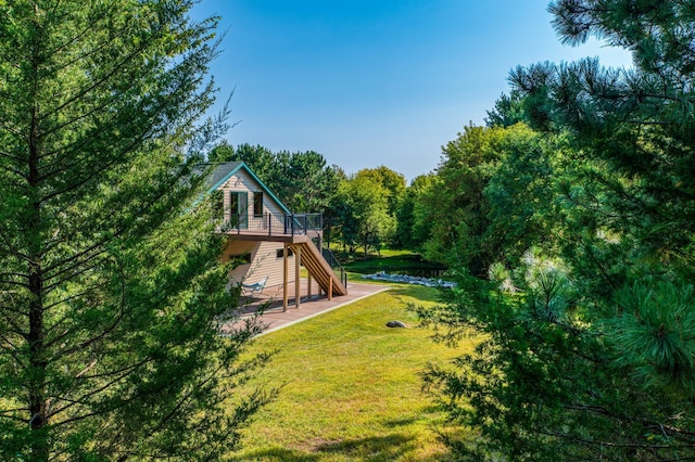 view of playground with a forest view, stairs, a yard, a deck, and a patio area