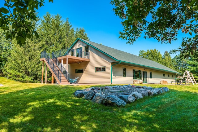 rear view of property with stairs, a yard, and a wooden deck