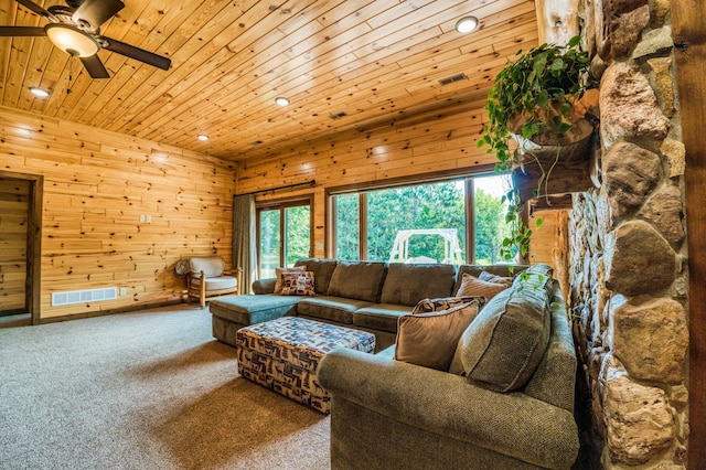 living area featuring wooden ceiling, wooden walls, and a ceiling fan