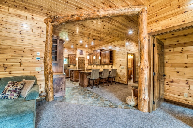 carpeted living area with beamed ceiling, wood ceiling, and wood walls