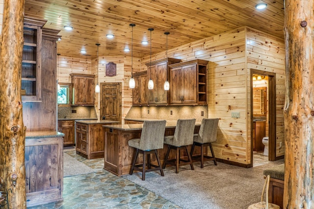 bar with stone finish floor, wooden ceiling, wood walls, decorative backsplash, and hanging light fixtures