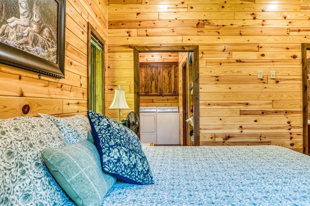 bedroom with washer and clothes dryer and wood walls