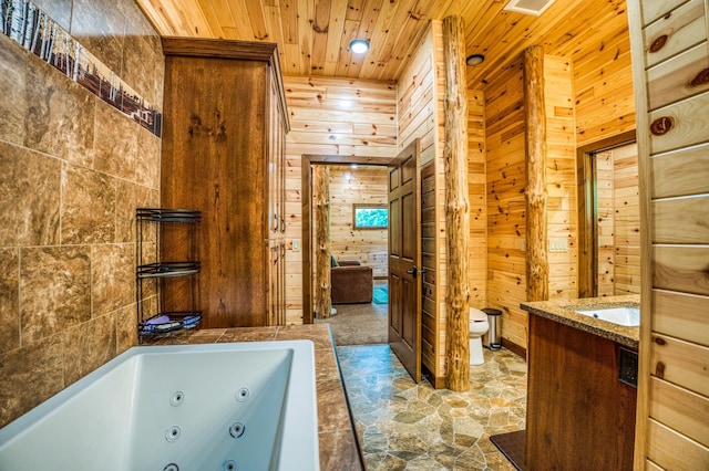 full bathroom featuring toilet, a jetted tub, wooden ceiling, wood walls, and vanity