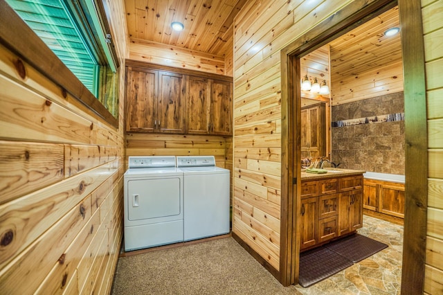 washroom featuring cabinet space, separate washer and dryer, wood walls, and wooden ceiling