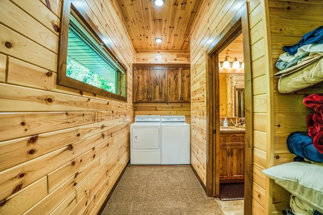 laundry room with cabinet space, wood ceiling, independent washer and dryer, and wood walls