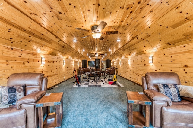 sitting room featuring ceiling fan, carpet floors, wood walls, and wooden ceiling