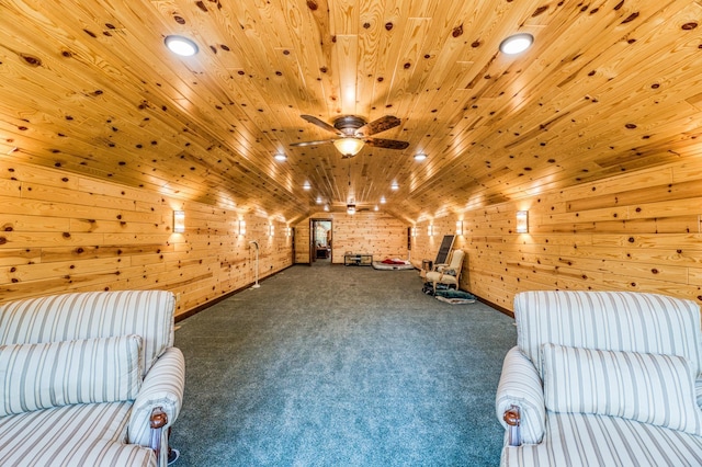 unfurnished room featuring ceiling fan, wood walls, wood ceiling, carpet floors, and vaulted ceiling