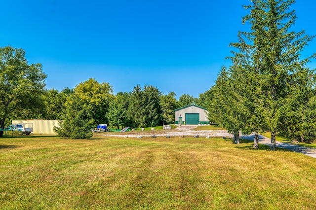 view of yard with an outdoor structure, a garage, and dirt driveway