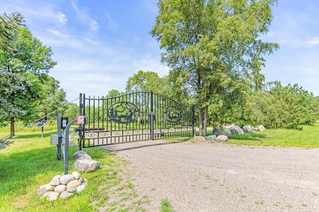 view of gate with a lawn