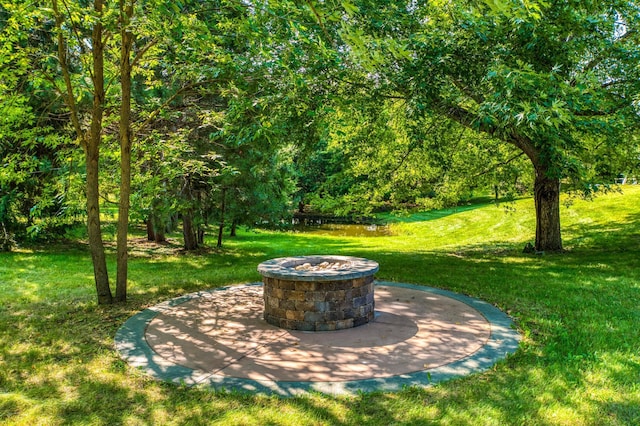 view of yard with a wooded view and a fire pit