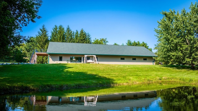 back of house featuring a yard and a water view