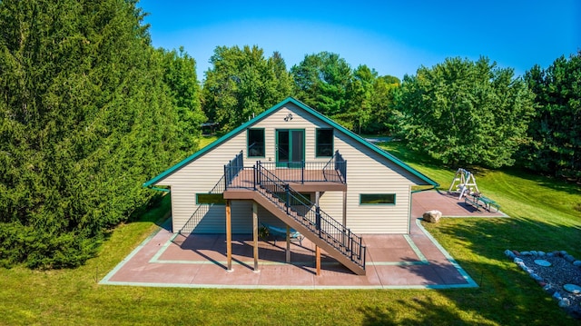 rear view of property featuring stairway, a lawn, a wooden deck, and a patio