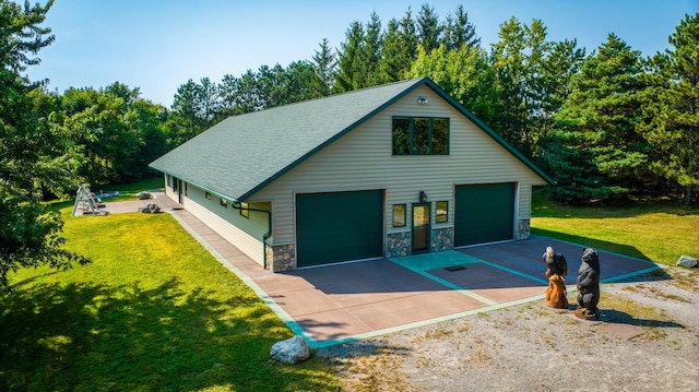 view of front of home with stone siding, a detached garage, roof with shingles, and a front yard