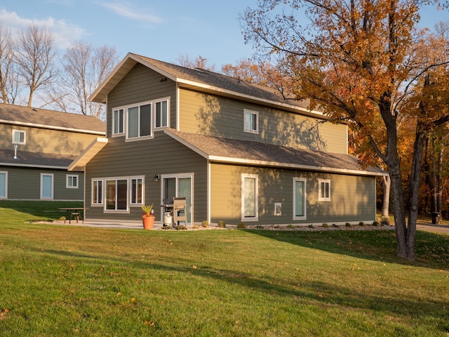 back of property featuring a lawn