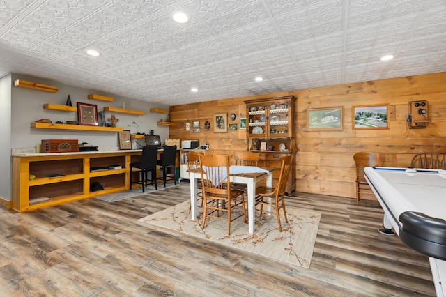 dining room with wood walls and hardwood / wood-style floors