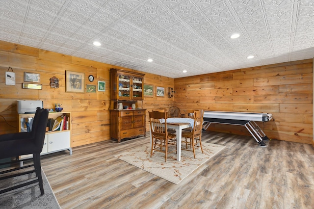 dining space featuring wood-type flooring and wood walls