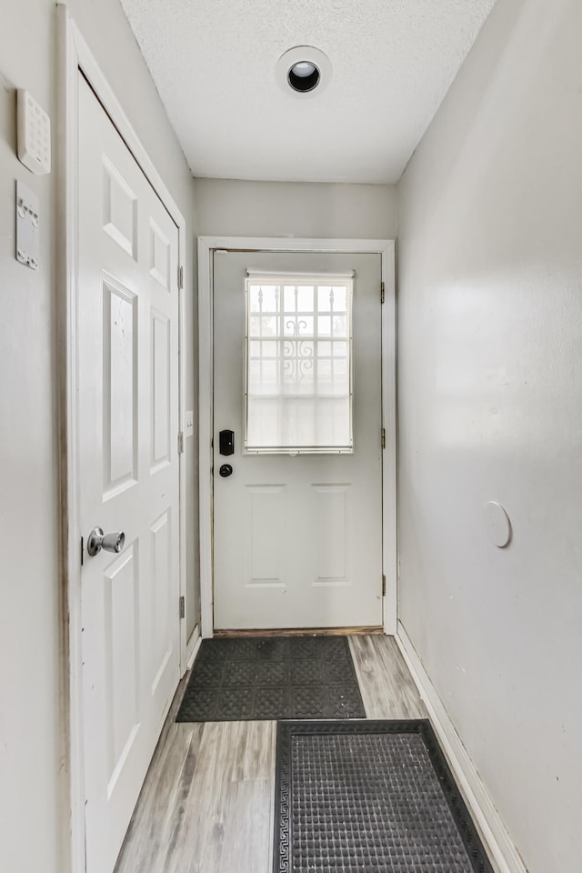 entryway featuring a textured ceiling and light hardwood / wood-style floors