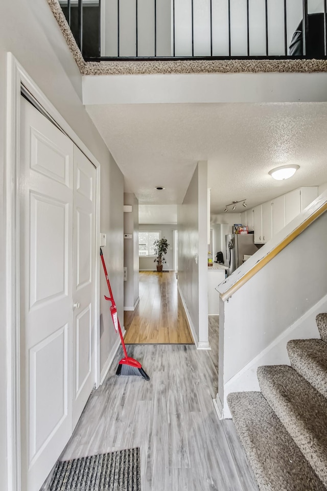 entrance foyer with light hardwood / wood-style floors and a textured ceiling