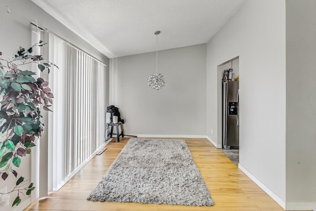 entrance foyer featuring a textured ceiling, lofted ceiling, and hardwood / wood-style floors